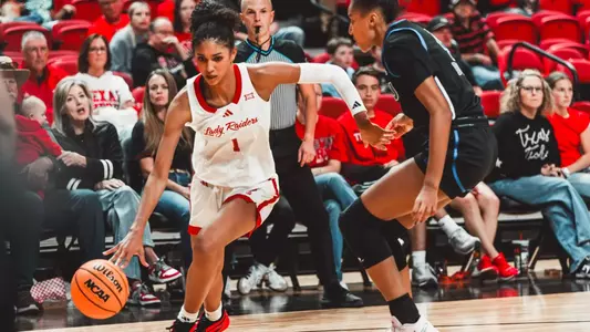Jalynn Bristow - Texas Tech Lady Raiders player wearing jersey number 1 drives past a defender while dribbling the ball during a home game.