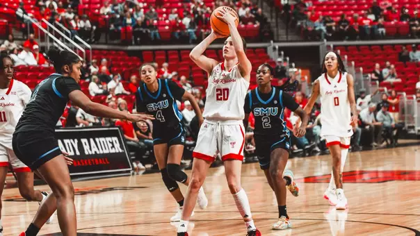 Texas Tech Lady Raiders guard Bailey Maupin, number 20, rises for a jump shot in the lane against SMU defenders during a home game.