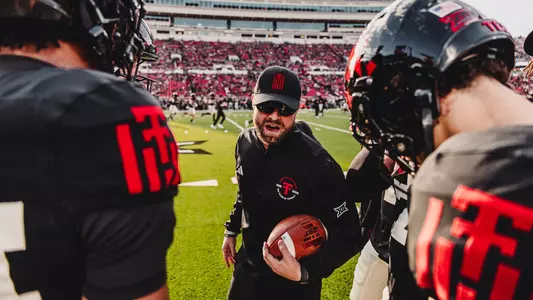 Texas Tech safeties coach Rob Greene speaks to his position groups during warmups prior to the Red Raiders' home game against Kansas.
