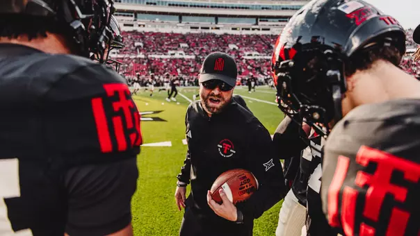 Texas Tech safeties coach Rob Greene speaks to his position groups during warmups prior to the Red Raiders' home game against Kansas.