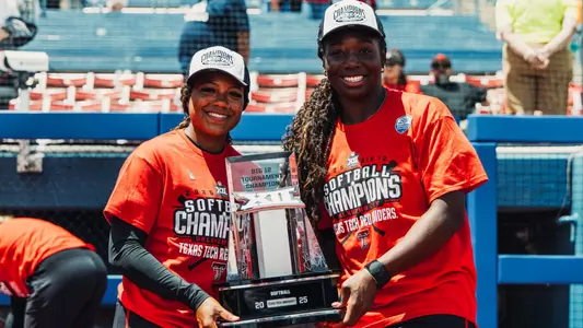 NiJaree Canady and Mihyia Davis holding the Big 12 tournament championship trophy