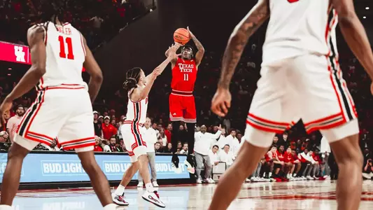 Texas Tech guard Jaylen Petty, in a red No. 11 jersey, rises for a jump shot over a Houston defender during a road game.