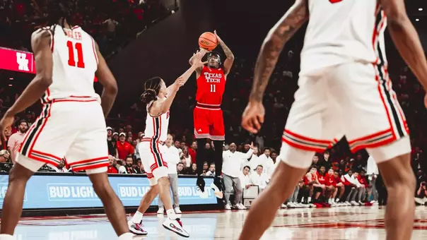 Texas Tech guard Jaylen Petty, in a red No. 11 jersey, rises for a jump shot over a Houston defender during a road game.