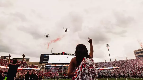 Two military helicopters fly over Galaxy Stadium at the end of the National Anthem prior to one of Texas Tech's 2025 home games.