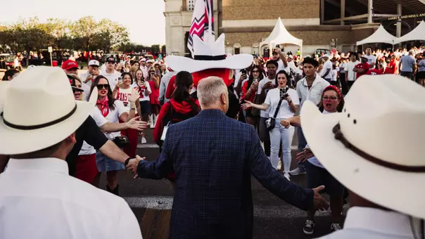 Joey McGuire shakes hands with Red Raider fans during Texas Tech's weekly "Raider Walk" entering the stadium.