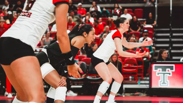 Texas tech volleyball players preparing for a serve from the other team