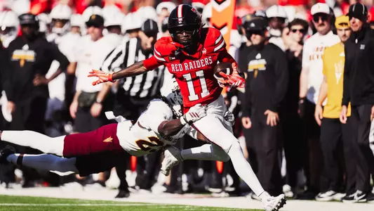 Malcolm Simmons rushes near the Arizona State sideline while a Sun Devil attempts to tackle him during Texas Tech's victory.