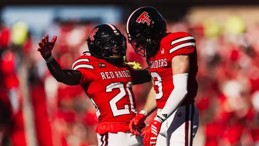 J'Koby Williams jumps into teammate Coy Eakin following his touchdown catch in the Red Raiders' win over Arizona State.