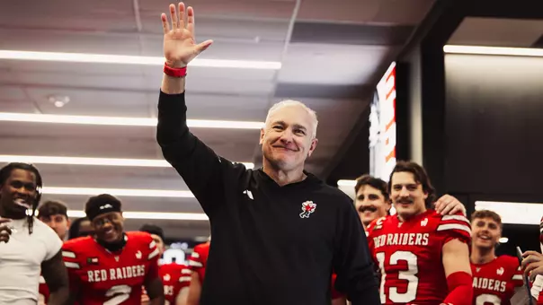 Joey McGuire raises his hand prior to addressing the Red Raiders in the locker room following Texas Tech's win over Arizona State.