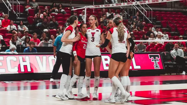 Texas Tech volleyball team huddled up at mid court after a point against UCF