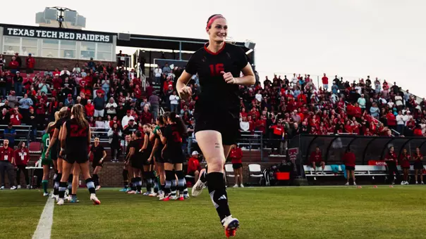 Taylor Zdrojewski running onto the field as part of the starting lineup group