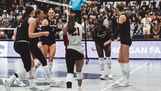 Texas Tech volleyball players celebrating a point as a team at Kansas State