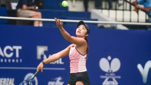 Kaili Teso throwing the ball up to serve.