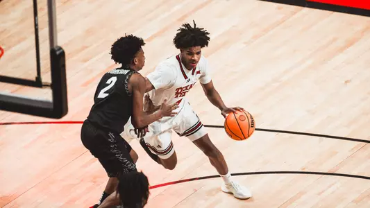 Christian Anderson dribbles through the lane with a Colorado defender attempting to guard him.