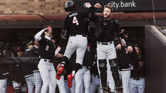 Texas Tech Freshman Infielder Linkin Garcia jumps in the air to lock arms in celebration with Davis Rivers after his eighth inning home run against UAlbany Friday