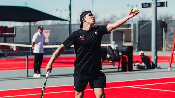 Ludovico Vaccari tossing a ball up to serve. Texas Tech Men's Tennis vs UNM on February 15, 2026 (Photo by Adele Clarke/Texas Tech Athletics)