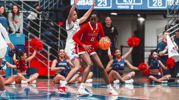 Sarengbe Sanogo dribbling the ball while being guarded by a Kansas player.