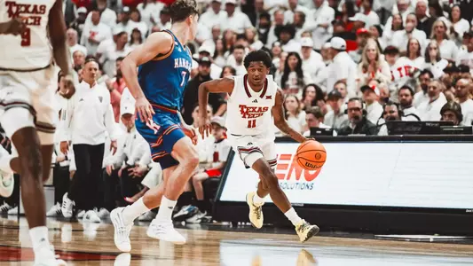 Jaylen Petty brings the basketball up the court against a Kansas defender.