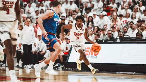 Jaylen Petty brings the basketball up the court against a Kansas defender.