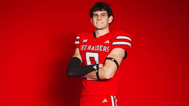 Texas Tech signee Reed Price stands with his arms crossed in front of a red backdrop as part of his Signing Day conent.