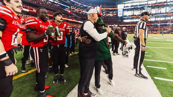Texas Tech head coach Joey McGuire hugs Director of Football Operations Quintin Jordan during the closing seconds of the Red Raiders' victory in the Big 12 Championship over BYU.
