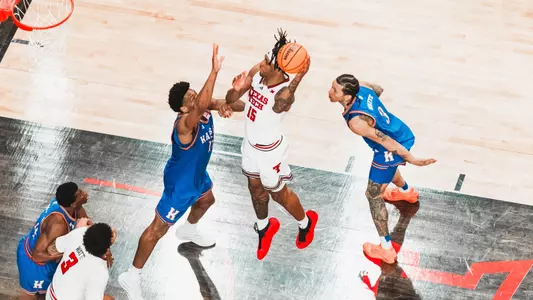 JT Toppin puts up a left-handed shot in the lane with two Kansas defenders attempting to stop him.