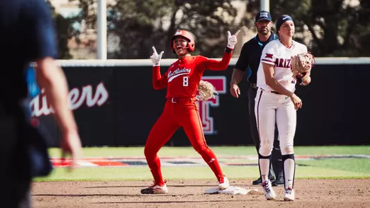 Desirae Spearman celebrating a hit with a guns up against Arizona