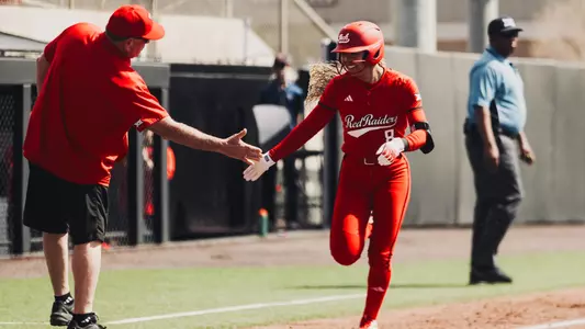 Desirae Spearman rounding third base high fiving coach gerry glasco after hitting a home run