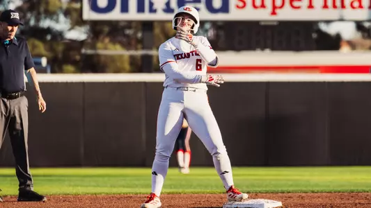 Taylor Pannell celebrating a hit against a team in a softball game