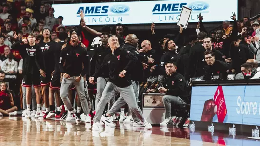 Grant McCasland and the Texas Tech bench celebrates a play during their win at Iowa State.