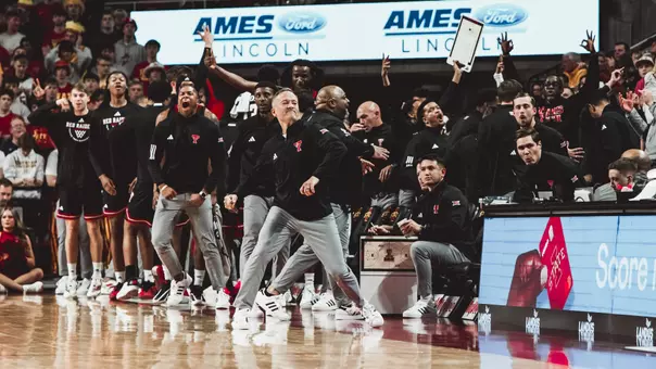Grant McCasland and the Texas Tech bench celebrates a play during their win at Iowa State.