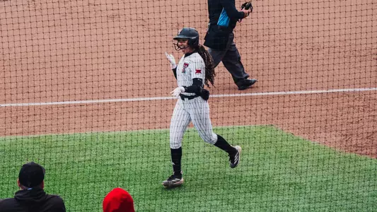 Desirae Spearman celebrating a home run with her teammates going back to the dugout