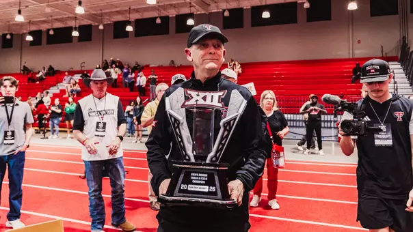 Wes Kittley holding the Big 12 Indoor trophy