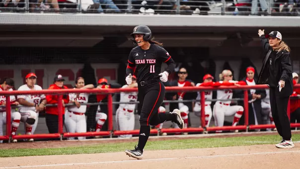Lauren Allred heading to home plate after a hitting a home run and celebrating with coach Tara Archibald in the background