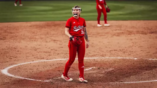 Kaitlyn Terry smiling after throwing a pitch in an all red jersey