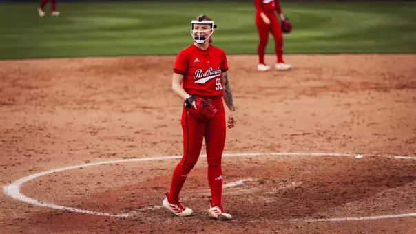 Kaitlyn Terry smiling after throwing a pitch in an all red jersey