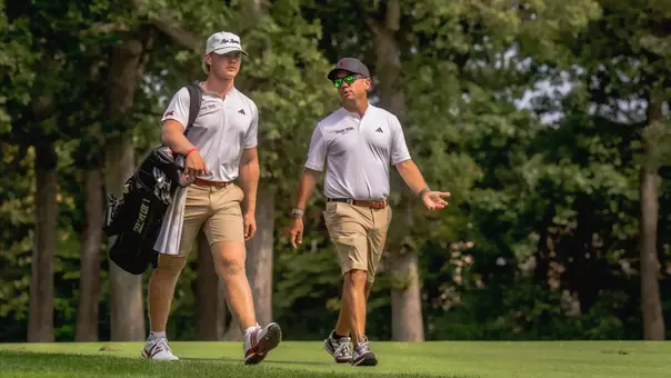 Associate head coach James Vargas walking with Brady McHenry