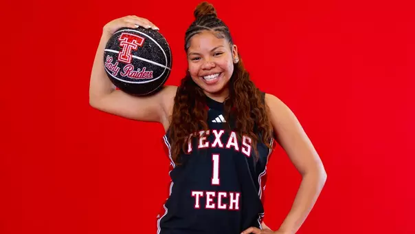 Kiki Smith smiling and holding a ball during a photoshoot.
