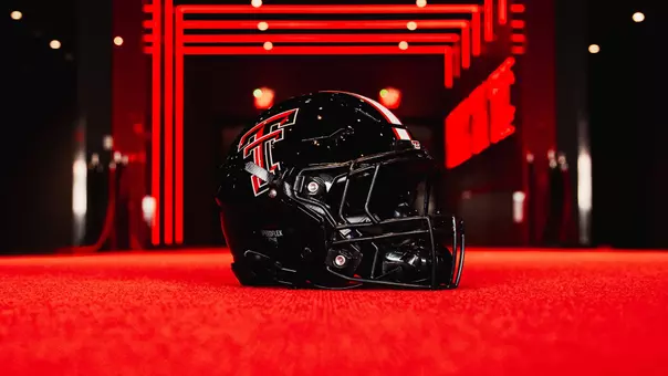 Picture of Texas Tech's black helmet sitting on the red carpet in the Gary Petersen Field Club.