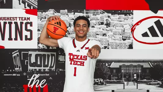 Damarion Dennis points to the camera and smiles during a recruiting visit at Texas Tech.