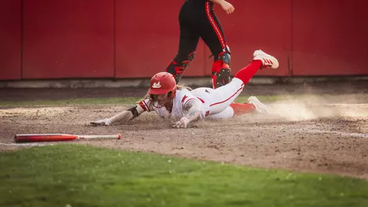 Kaitlyn Terry sliding home against Utah softball to score a run