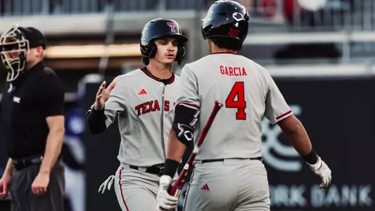 Kyler Thompson and Linkin Garcia slap hands and chat during Tech's 9-1 win in Abilene on Wednesday