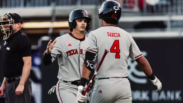 Kyler Thompson and Linkin Garcia slap hands and chat during Tech's 9-1 win in Abilene on Wednesday