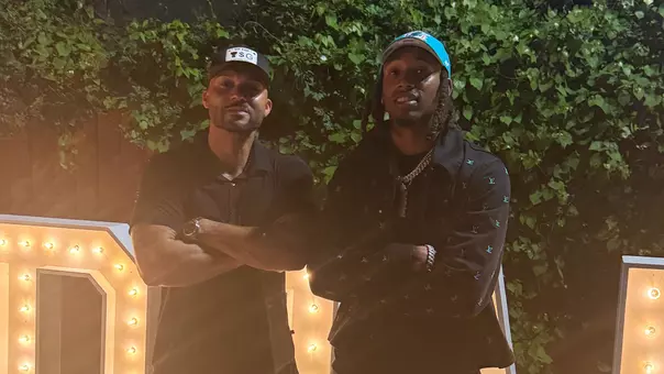 Caleb Douglas donning Miami Dolphins hat with Texas Tech coach Juice Johnson