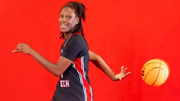 Jalayah Ingram tossing a basketball behind her in a photoshoot.