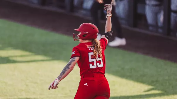 Kaitlyn Terry holding up her hand to celebrate a home run in softball while wearing a red jersey