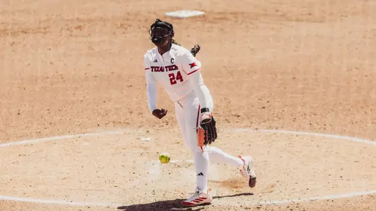 NiJaree Canady in all white jersey in her wind up to throw a pitch