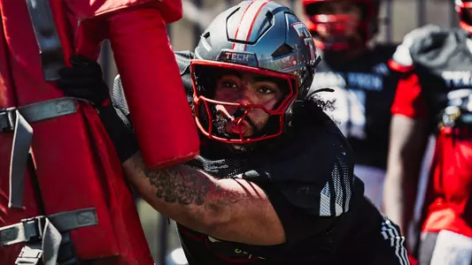 Julien Laventure hitting a pads during a drill in spring practice