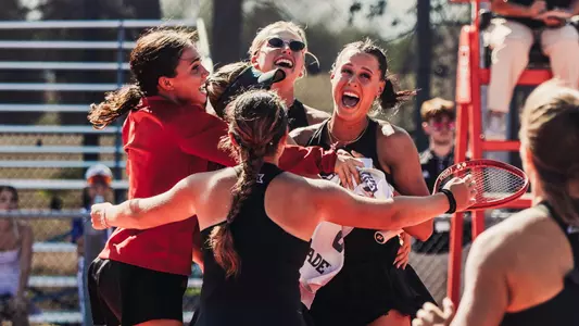 Girls in huddle celebrating Ella's match clinch