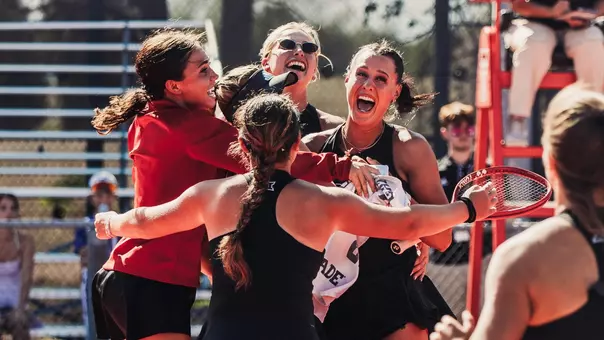 Girls in huddle celebrating Ella's match clinch